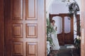 Gorgeous bride in white wedding dress walking in hall with plants, wedding day concept, beautiful woman with boutonniere Royalty Free Stock Photo