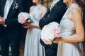 Gorgeous bridesmaids with peony bouquet and stylish groomsmen po