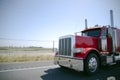 Gorgeous bright red shiny big rig semi truck with chrome parts a