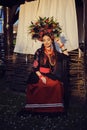 Brunette girl in a white ukrainian authentic national costume and a wreath of flowers is posing against a terrace. Close Royalty Free Stock Photo