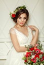 Gorgeous brunette girl in a white dress, with a wreath and a bouquet Royalty Free Stock Photo