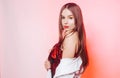 A gorgeous brunette in a shiny red dress is dancing, a model in a white jacket is having fun. Girl in yellow accessories, earrings Royalty Free Stock Photo