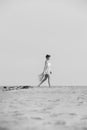 Gorgeous brunette woman in dress walking in the desert sand Royalty Free Stock Photo