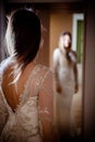 Gorgeous brunette woman with long hair and blue eyes looking herself in the mirror Royalty Free Stock Photo