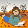 Gorgeous brunette woman reading a book in autumn park