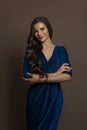 Gorgeous brunette woman wearing blue dress on brown background Royalty Free Stock Photo