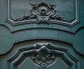 Gorgeous carving volute and relief sculptural frames of green painted wooden door. Architectural details of Paris door of baroque