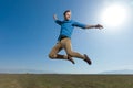 Casual man wearing blue shirt jumping high to the sky Royalty Free Stock Photo