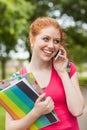 Gorgeous cheerful student holding notebooks phoning Royalty Free Stock Photo