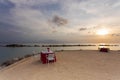 Gorgeous colorful view of sunset on Curacao island. Beautiful view of tables covered with white cloth on coast of Atlantic ocean.