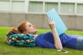 Gorgeous concentrating student lying on grass reading notes Royalty Free Stock Photo