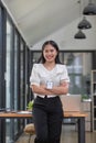 Gorgeous and confident Asian businesswoman or female manager in formal suit standing at her desk, holding a coffee cup Royalty Free Stock Photo