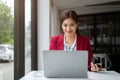 A gorgeous Asian female call centre operator is managing her work on her laptop