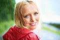 Gorgeous country girl. Gorgeous young blonde woman wearing a red raincoat in the rain outdoors on a country road. Royalty Free Stock Photo