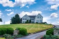 Gorgeous country home on hill with large green lawn, landscaping and front yard driveway Royalty Free Stock Photo