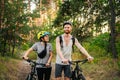 Gorgeous couple riding on bikes in park forest. Romantic trip by bicycles. Active weekend. Sport couple. Man and woman cyclists. Royalty Free Stock Photo