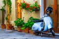 Fantastic Italian street with colorful flowers and scooter, Pienza, Tuscany