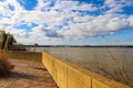 A gorgeous day at Mud Island Park along the Mississippi river with a red brick footpath, green benches, bare winter trees