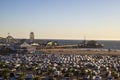 A gorgeous day at Santa Monica Pier with roller coasters, a Ferris wheel, lush green palm trees and grass, ocean water and people Royalty Free Stock Photo