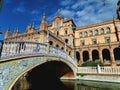 Gorgeous decorated bridge and stunning architecture against vivid blue sky at Plaza de Espana of Seville