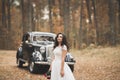 Gorgeous elegant bride posing near stylish retro black car Luxury wedding in vintage style. Portrait Royalty Free Stock Photo