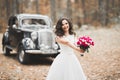 Gorgeous elegant bride posing near stylish retro black car Luxury wedding in vintage style. Portrait Royalty Free Stock Photo