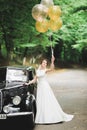 Gorgeous elegant bride posing near stylish retro black car Luxury wedding in vintage style. Portrait Royalty Free Stock Photo