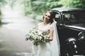 Gorgeous elegant bride posing near stylish retro black car Luxury wedding in vintage style. Portrait Royalty Free Stock Photo