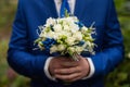 gorgeous elegant groom in blue suit holding stunning stylish bouquet Royalty Free Stock Photo