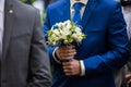gorgeous elegant groom in blue suit holding stunning stylish bouquet Royalty Free Stock Photo