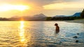 Gorgeous family pet dog on a beach at sunset. Vizsla puppy on summer vacation exploring the sea.