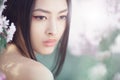 Portrait of a beautiful fantasy asian girl outdoors against natural spring flower background. Royalty Free Stock Photo