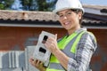 gorgeous female bricklayer holding concrete block