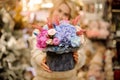 Gorgeous flower arrangement in round box in the hands of woman.
