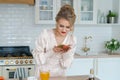 Gorgeous girl in beautiful dress eats ripe strawberries in kitchen. Luxurious Royalty Free Stock Photo