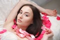 Gorgeous girl lying in rose petals. Royalty Free Stock Photo