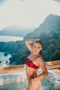 Gorgeous girl in an outdoor Jacuzzi with a beautiful view of the sea and mountains Royalty Free Stock Photo