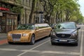 Gorgeous golden color limousine on the city street.