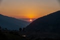 Gorgeous golden hour sunset in Uttarakhand\'s Himalayan Nag Tibba, featuring a round sun at its center