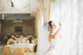 Gorgeous happy luxury brunette bride near a window on the background of vintage room