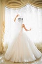 Gorgeous happy luxury brunette bride near a window on the background of vintage room