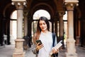 Gorgeous happy student holding notebooks texting on campus at college Royalty Free Stock Photo