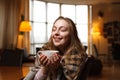 Gorgeous happy woman drinks coffee at a cafe background. Covered cozy plaid.