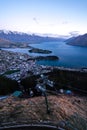 Gorgeous image of Queenstown with snow capped mountains in the background taken during an orange sunset from Skyline Queenstown,