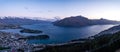 Gorgeous image of Queenstown with snow capped mountains in the background taken during an orange sunset from Skyline Queenstown,