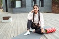 A gorgeous Indian woman with long hair is sitting on a fitness mat, relaxing after a workout. Royalty Free Stock Photo