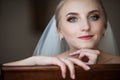 Gorgeous innocent blonde bride posing while sitting on chair, fa Royalty Free Stock Photo