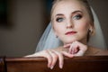 Gorgeous innocent blonde bride posing while sitting on chair, fa Royalty Free Stock Photo