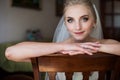 Gorgeous innocent blonde bride posing while sitting on chair, fa Royalty Free Stock Photo