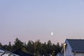 Gorgeous landscape view. Early crescent moon in evening sky over hose roofs Royalty Free Stock Photo